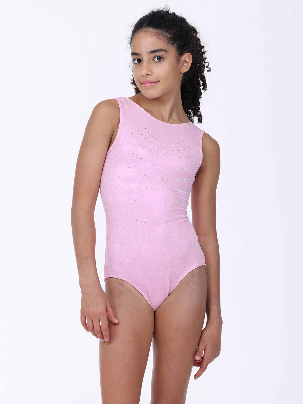 Young girl wearing a pink gymnastics leotard with rhinestones detailing on a white background