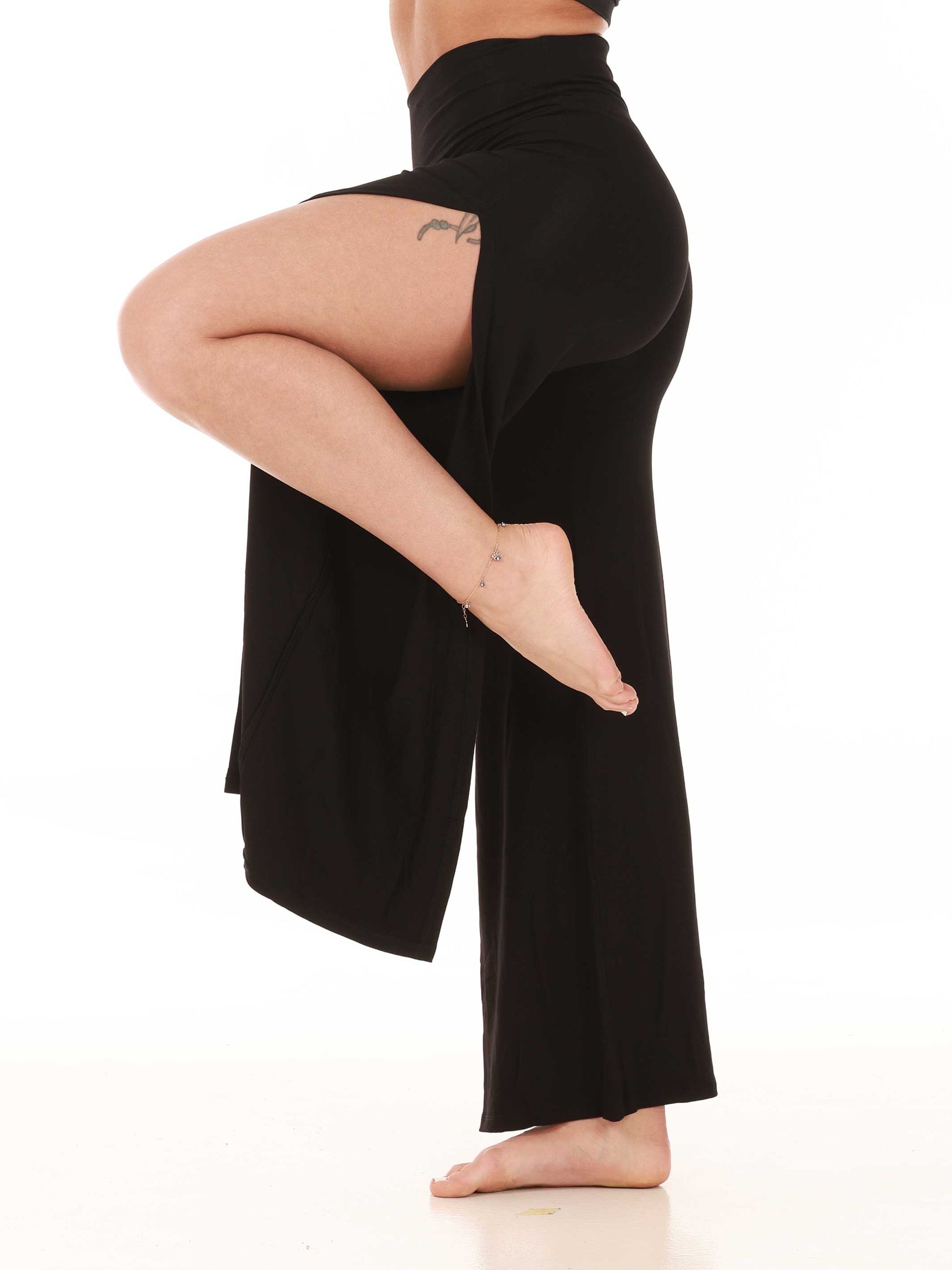 Person wearing black wide-leg jazz pants on a white background