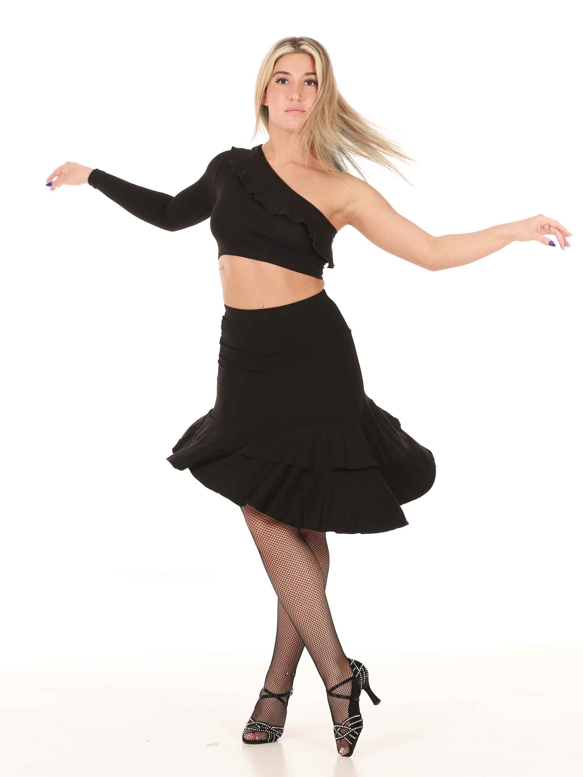 Dancer wearing a black crop top and latin dance skirt on a white background