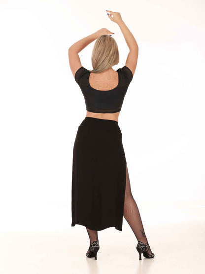 Dancer wearing a black dance skirt and top on a white background