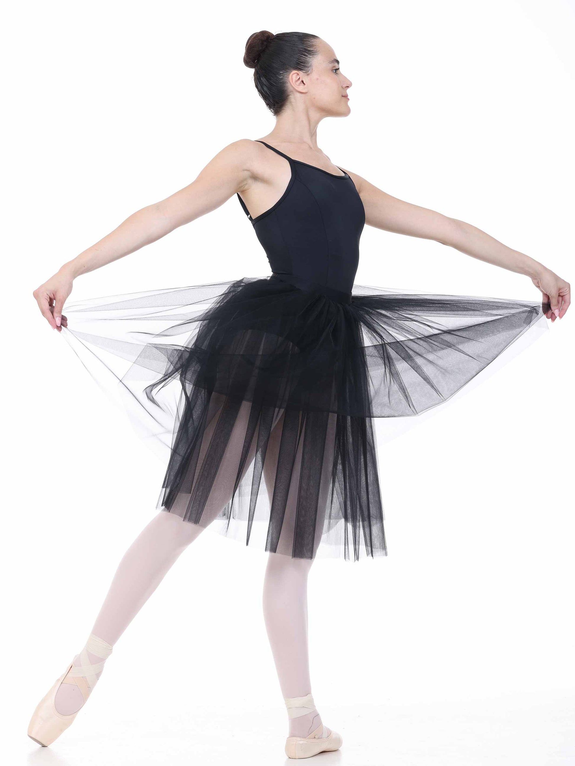 Ballerina in a black leotard and tutu on a white background