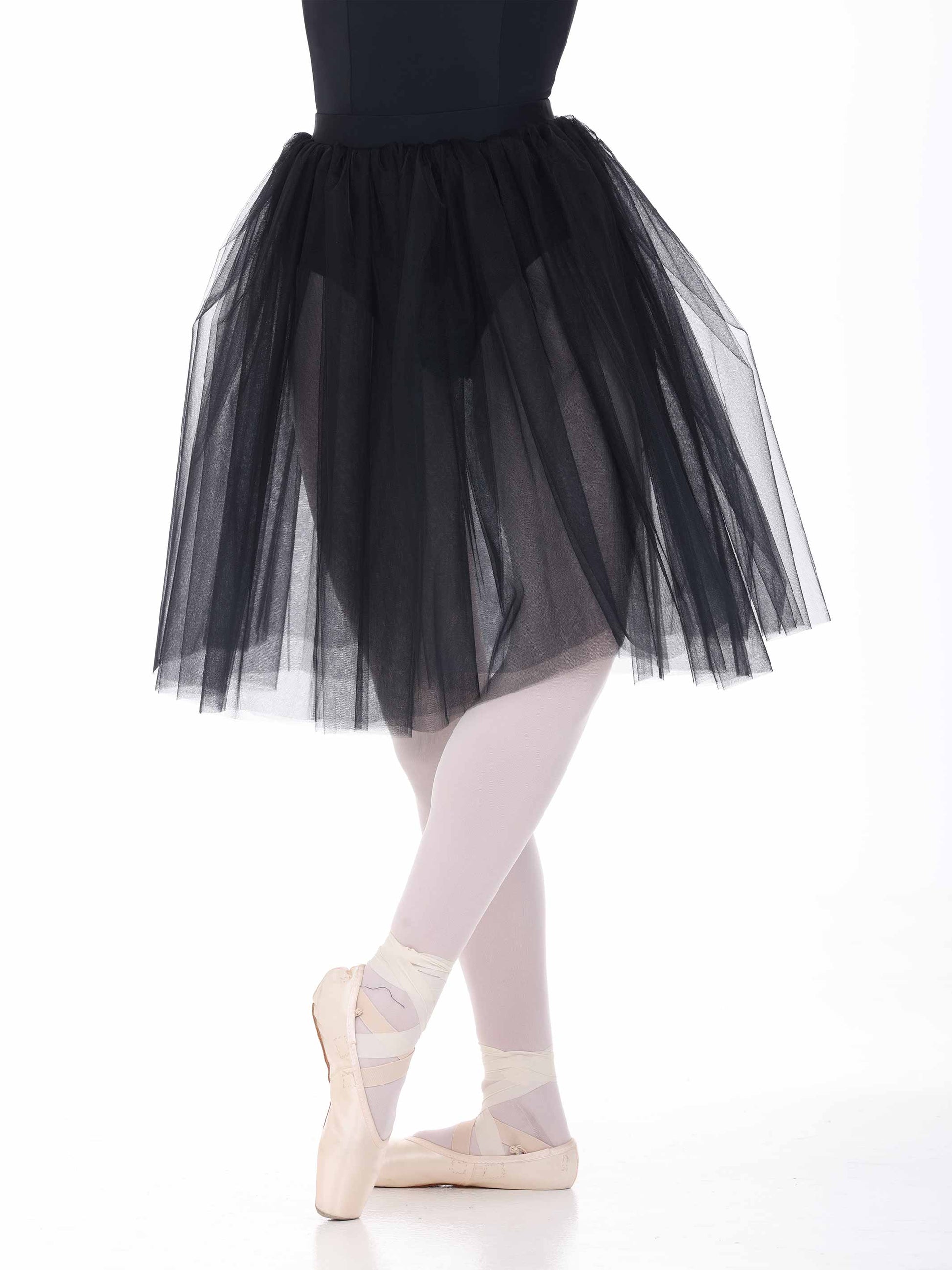 Ballerina wearing a black tutu and white tights on a white background