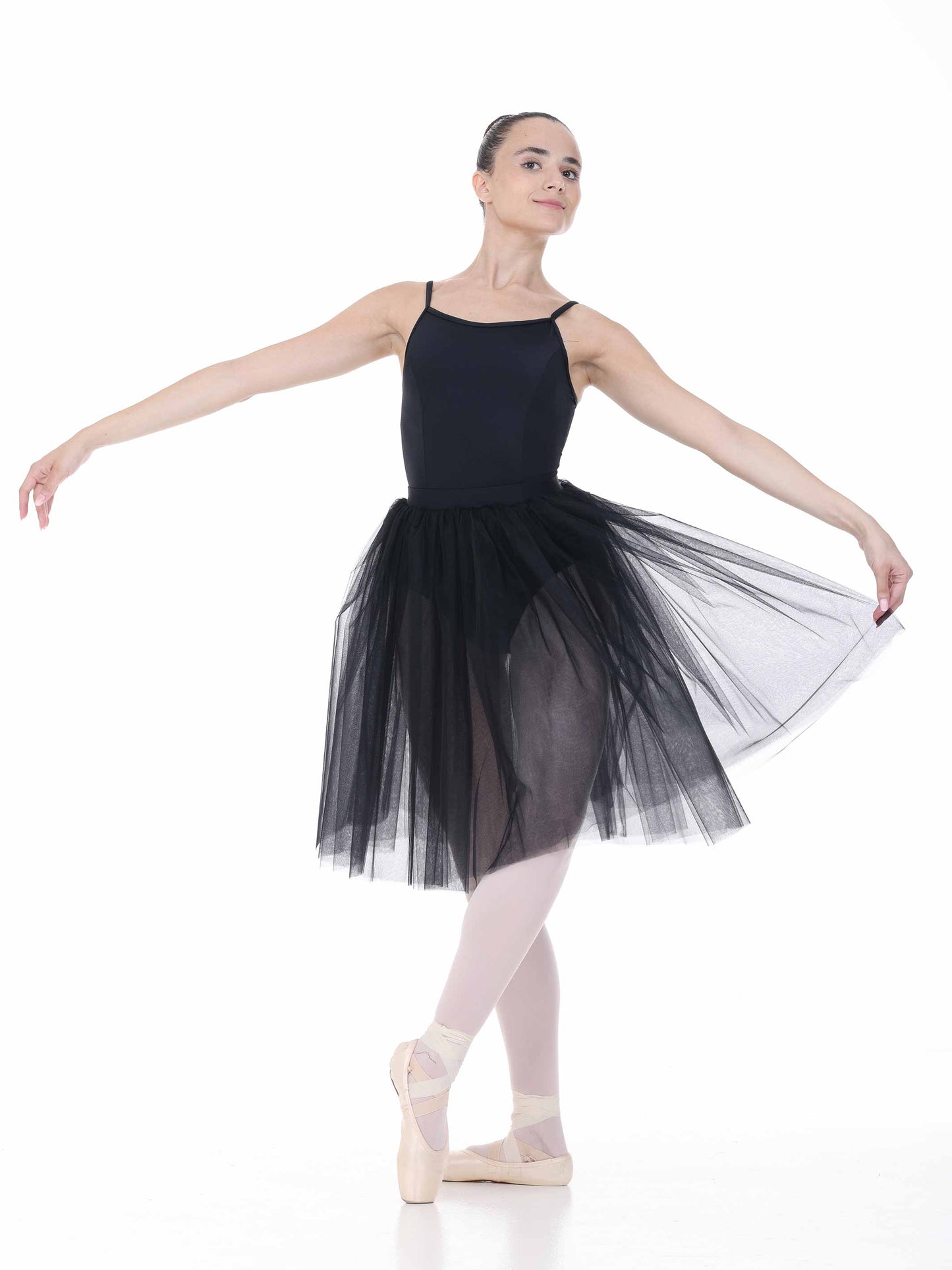 Ballerina in a black tutu posing on a white background