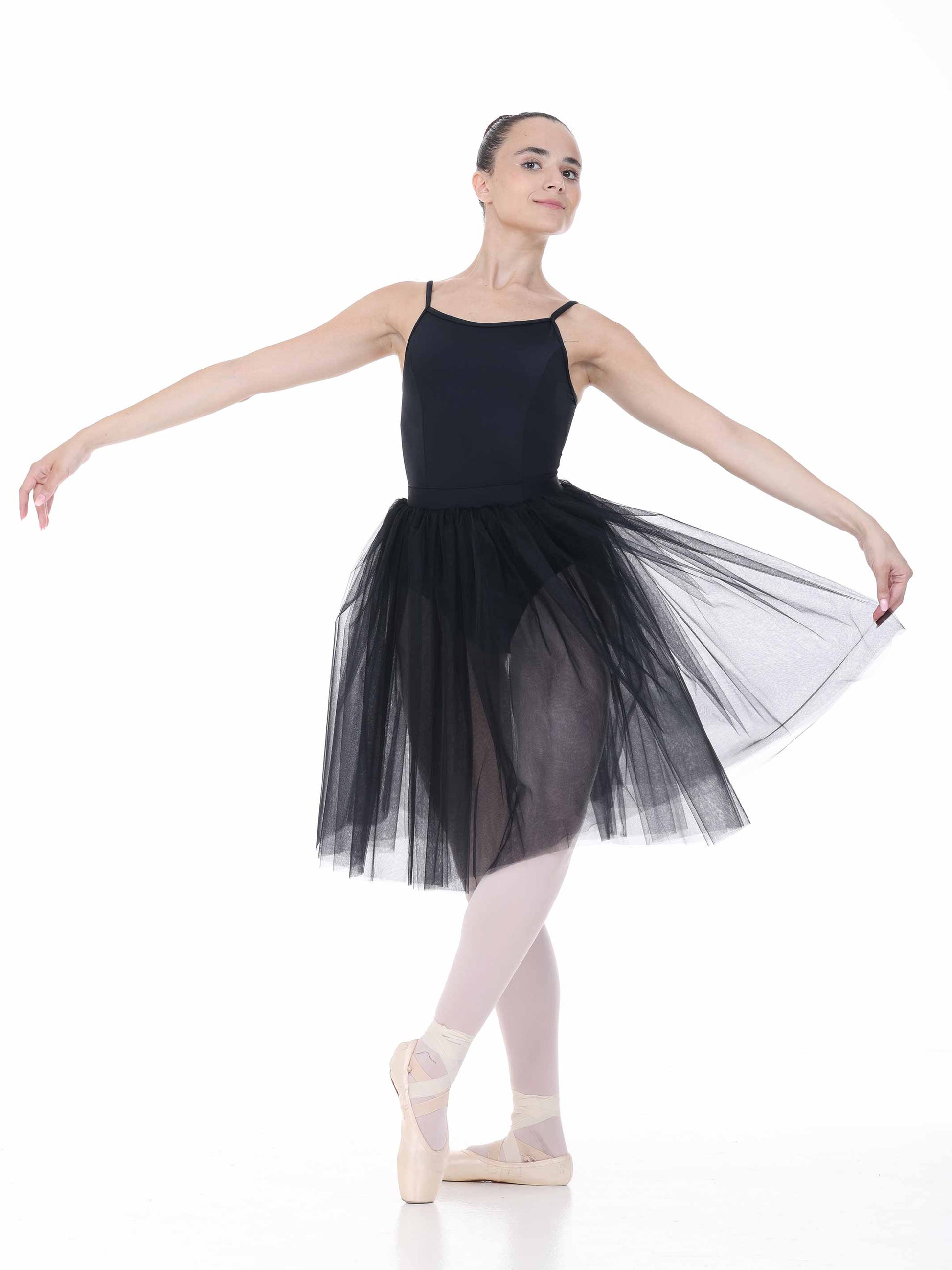 Ballerina in a black tutu posing on a white background