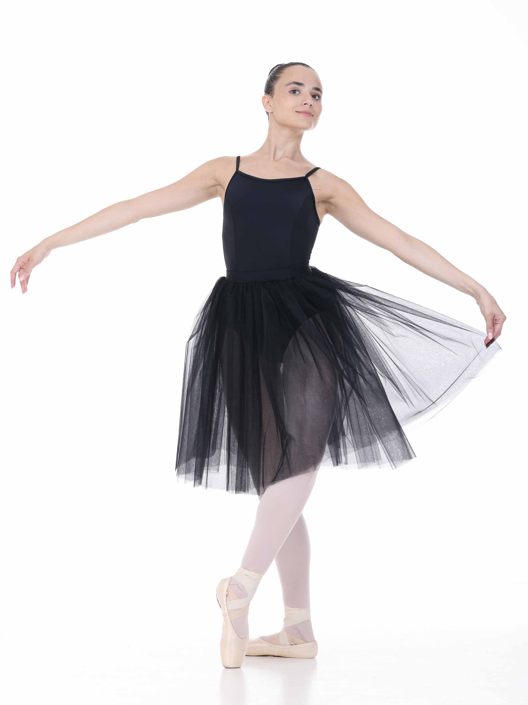 Ballerina in a black tutu posing on a white background