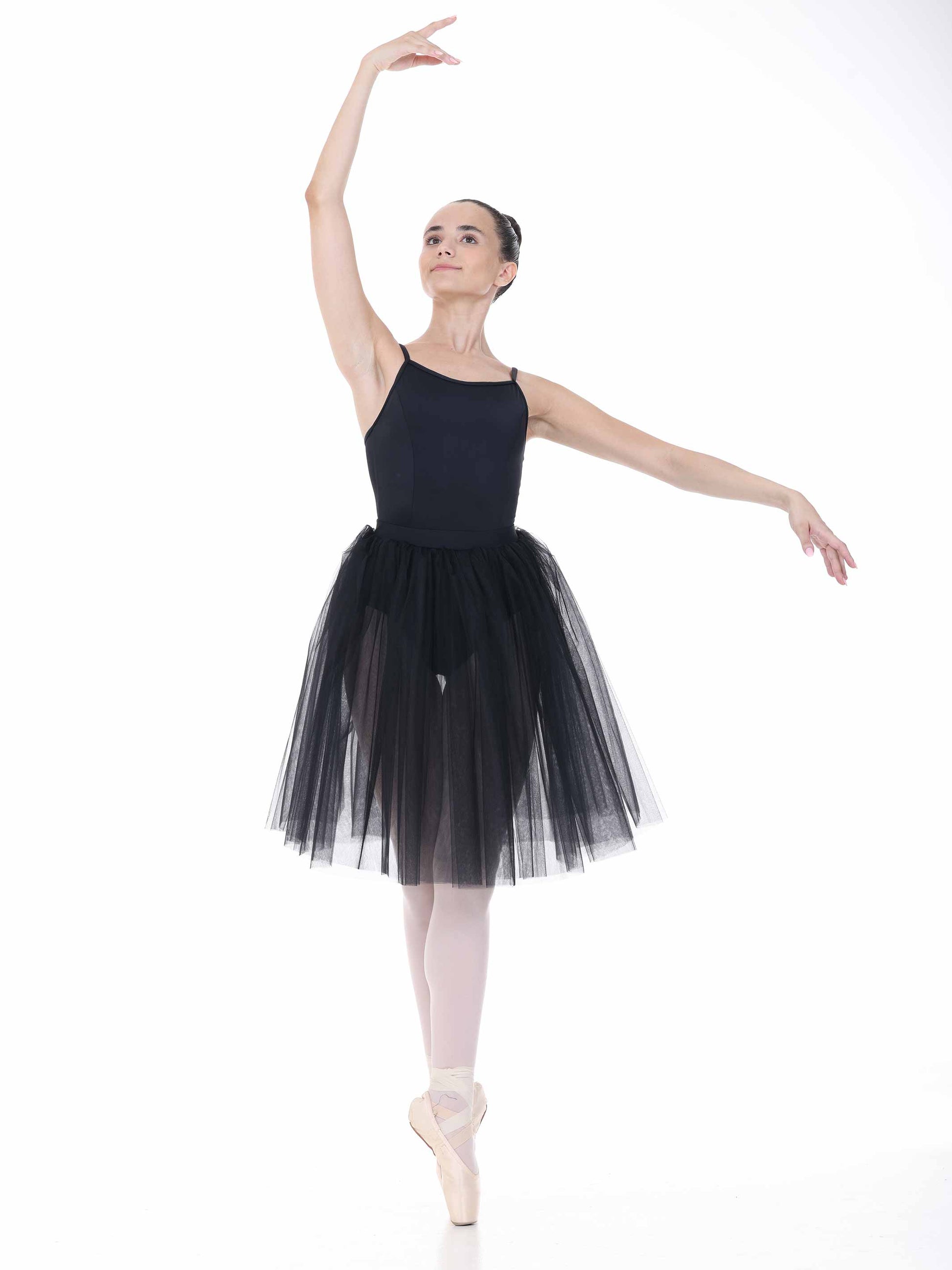 Ballerina in a black tutu posing on a white background