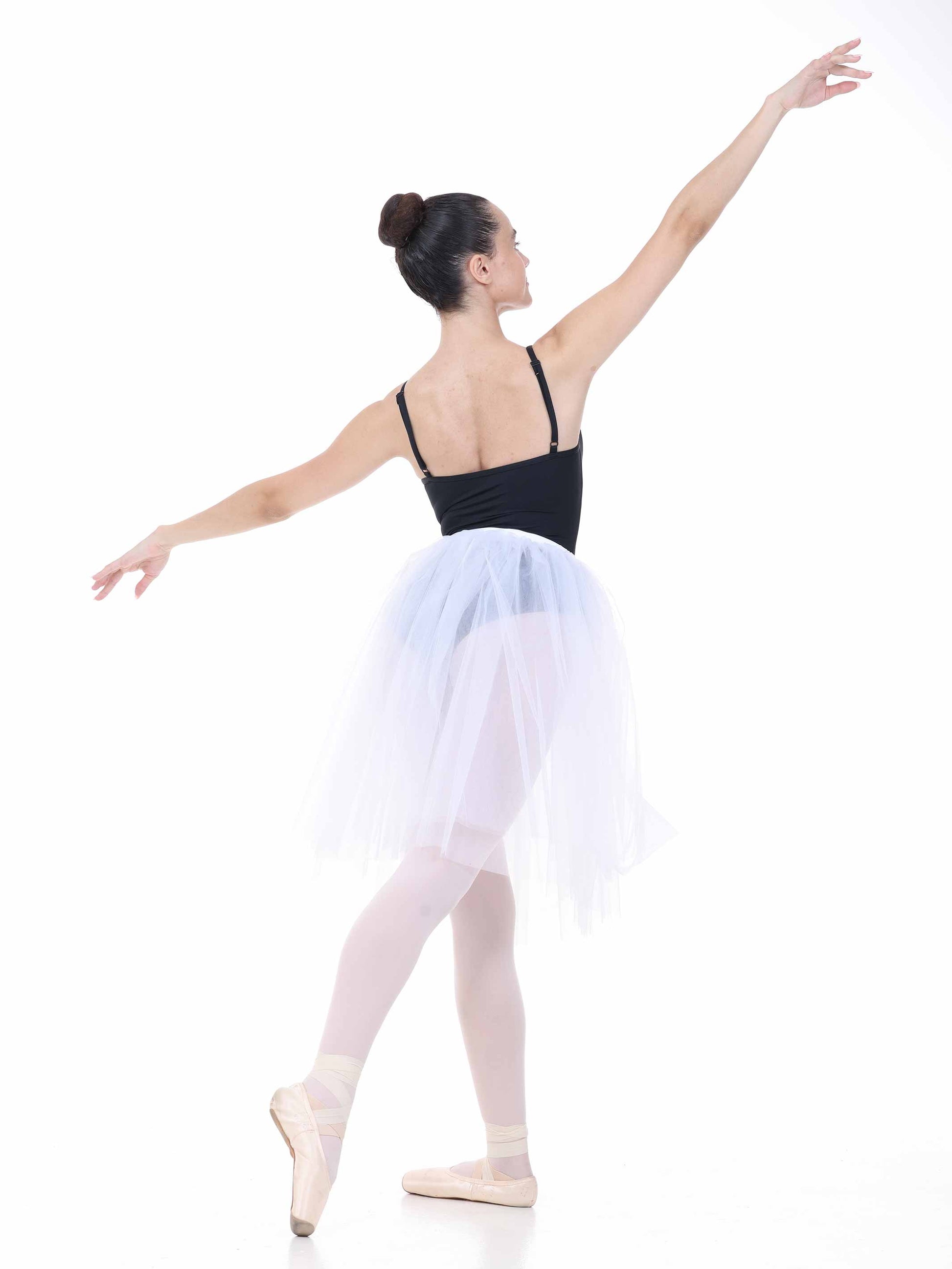 Ballerina in a black top and white tutu posing on a white background