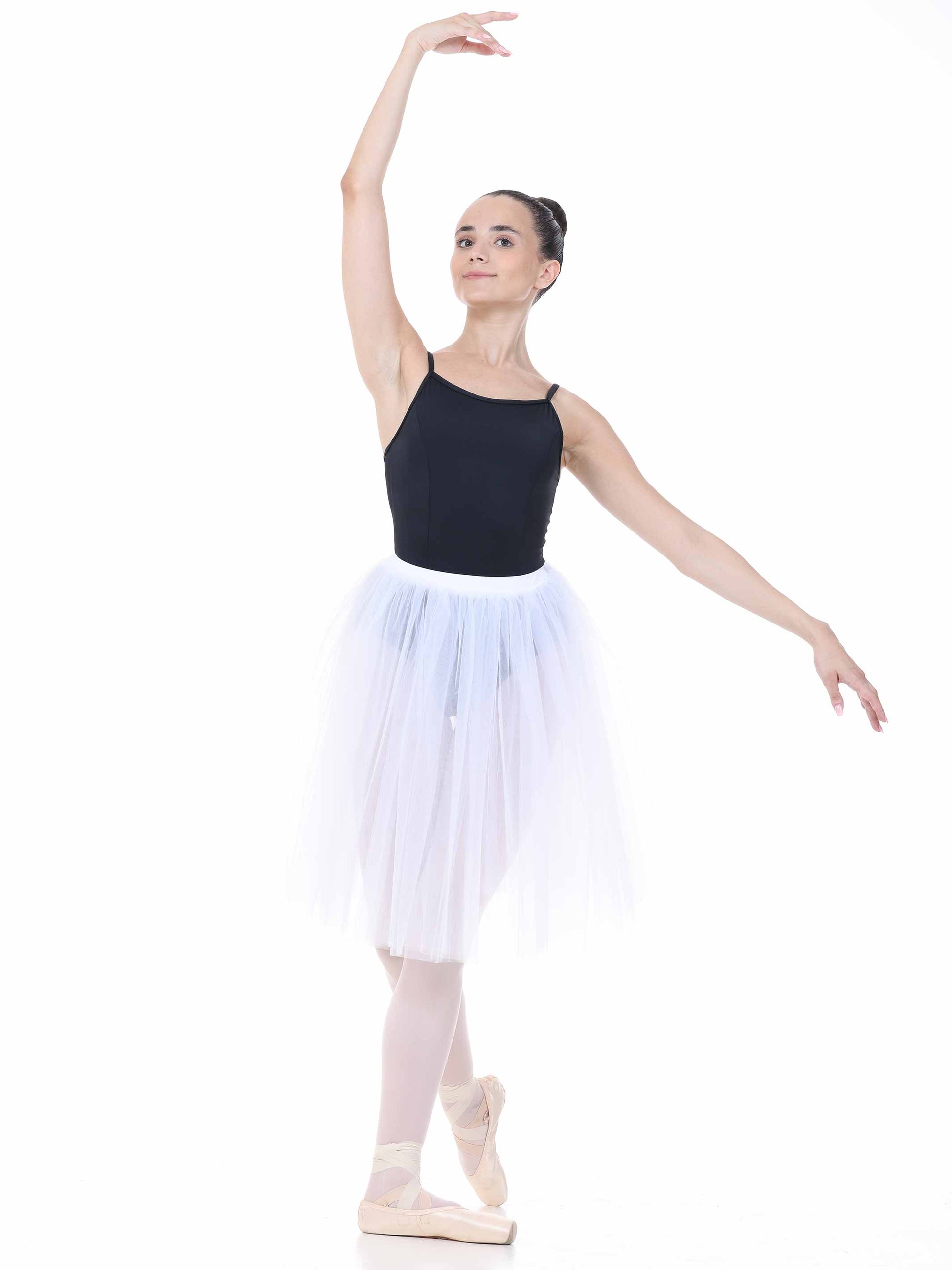 Ballerina in a black top and white tutu posing on a white background