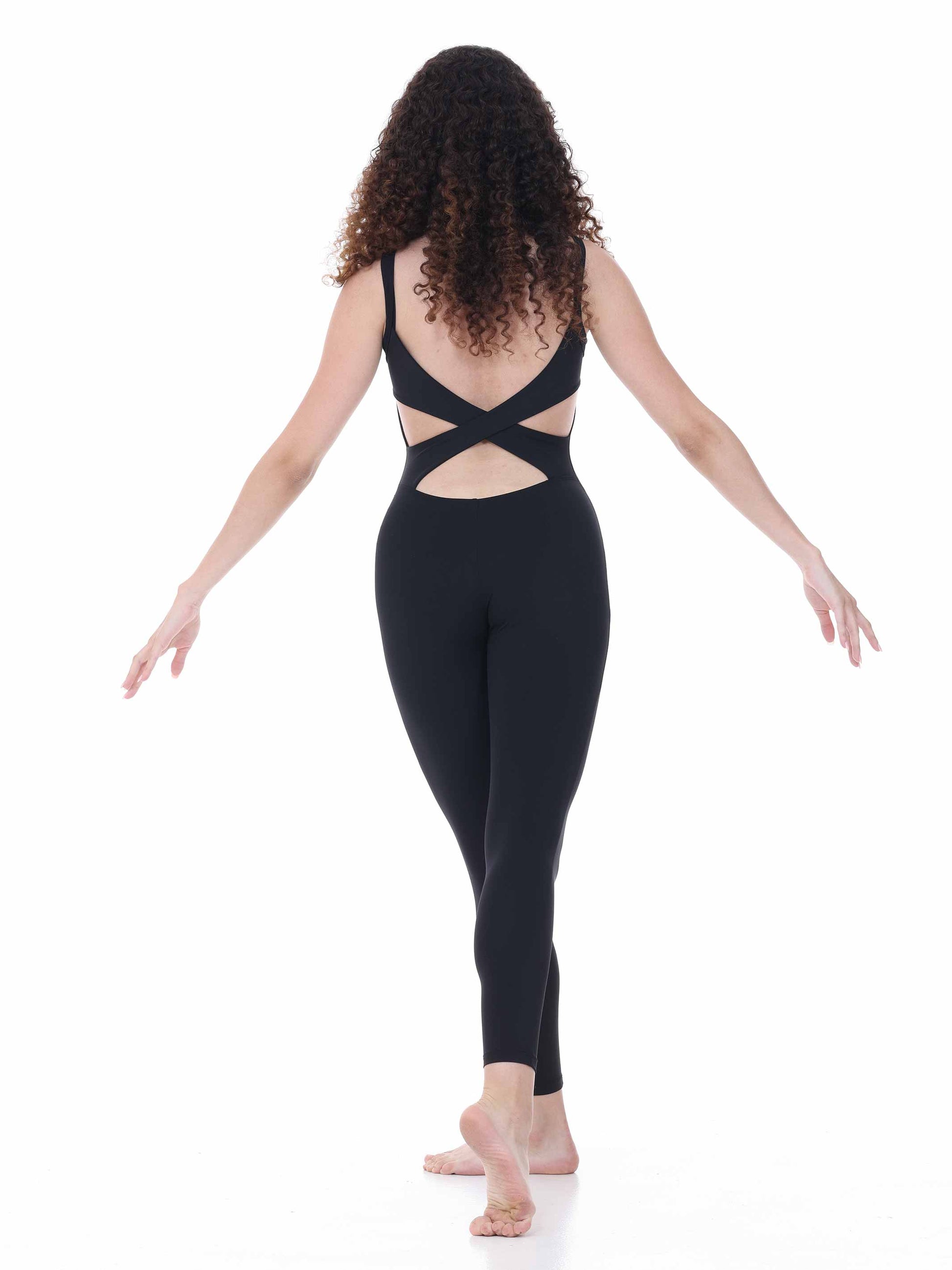 Woman wearing a black unitard with cut-out design on a white background