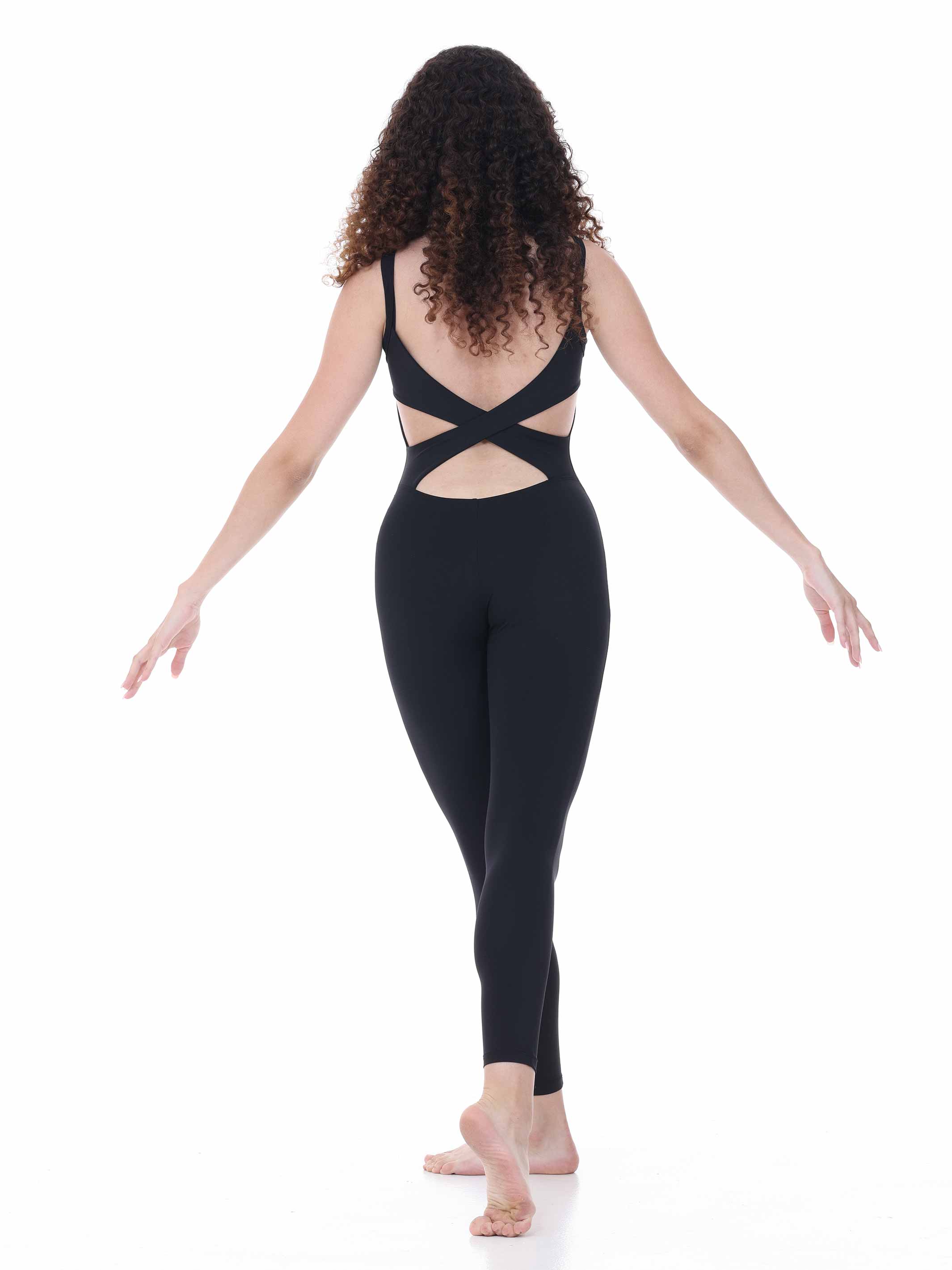 Woman wearing a black unitard with cut-out design on a white background